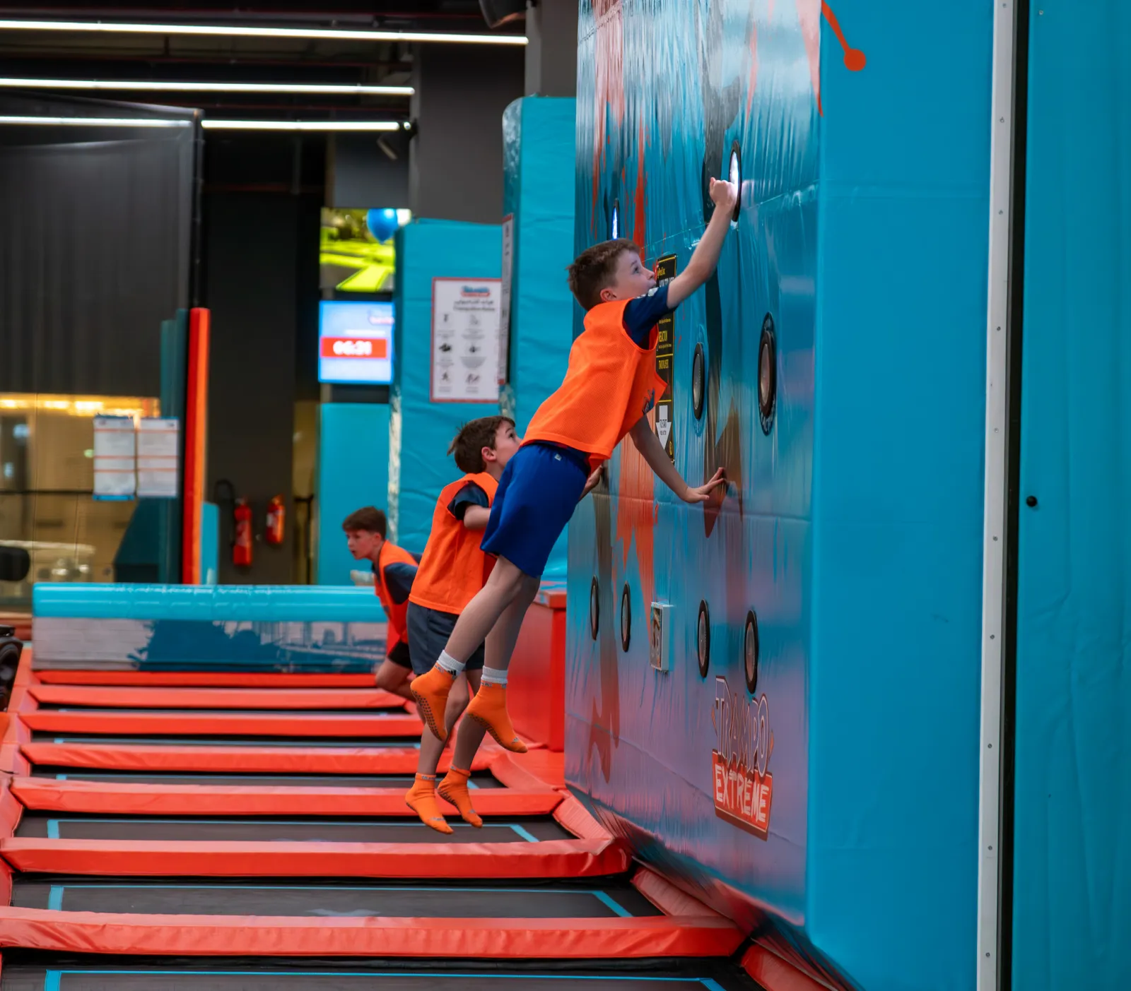 Kids bouncing and hitting targets on the interactive wall at Trampo