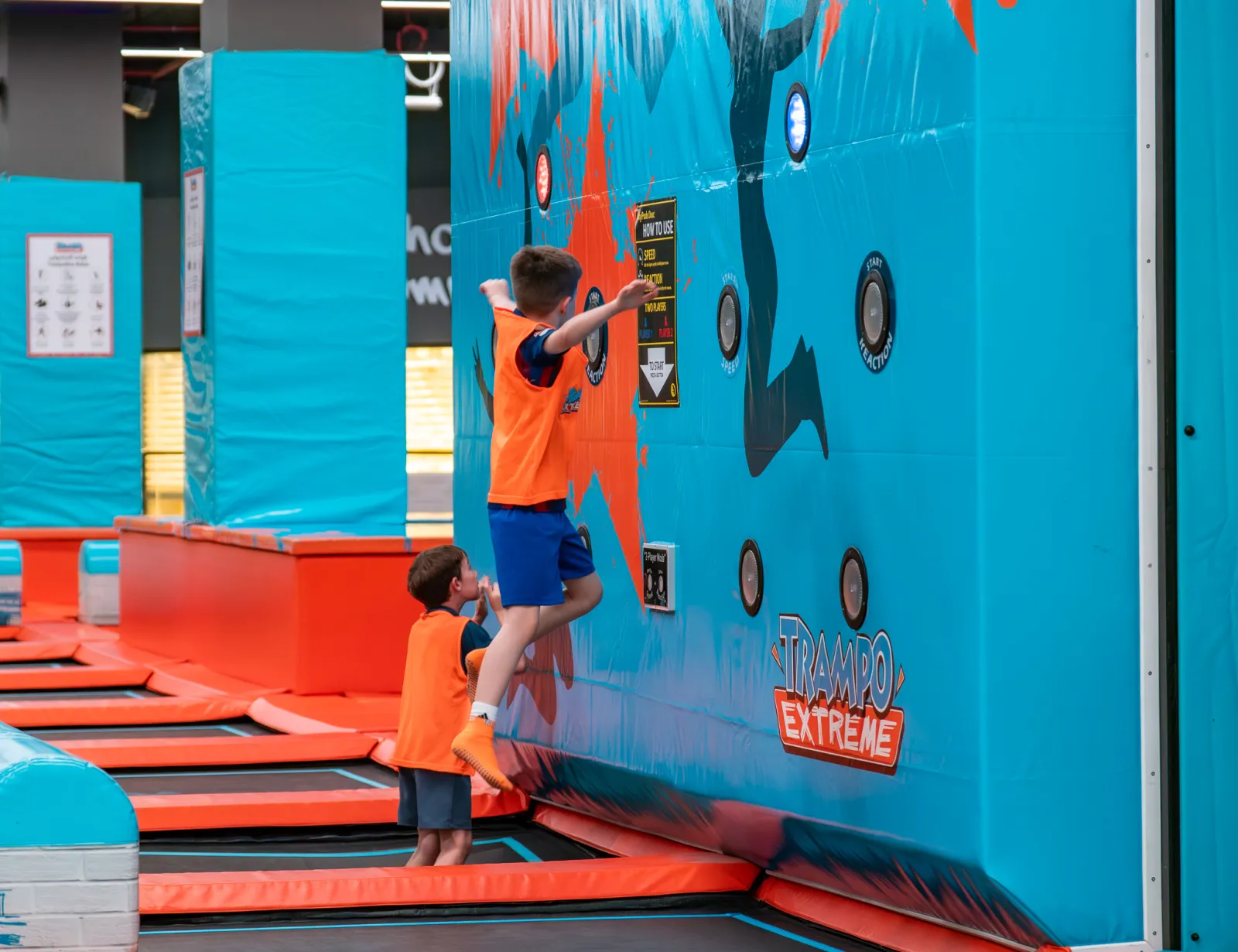Two boys competing on the interactive wall at Trampo
