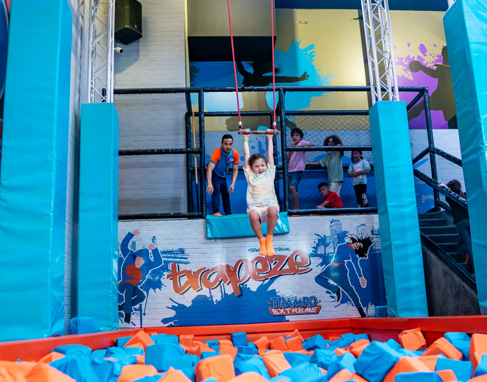 Girl swinging on the trapeze at Trampo